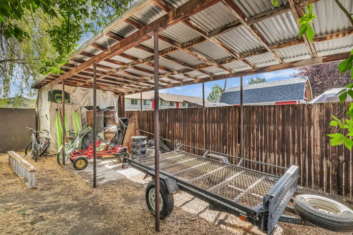 Expansive covered outdoor structure featuring a corrugated metal roof and exposed wood framing