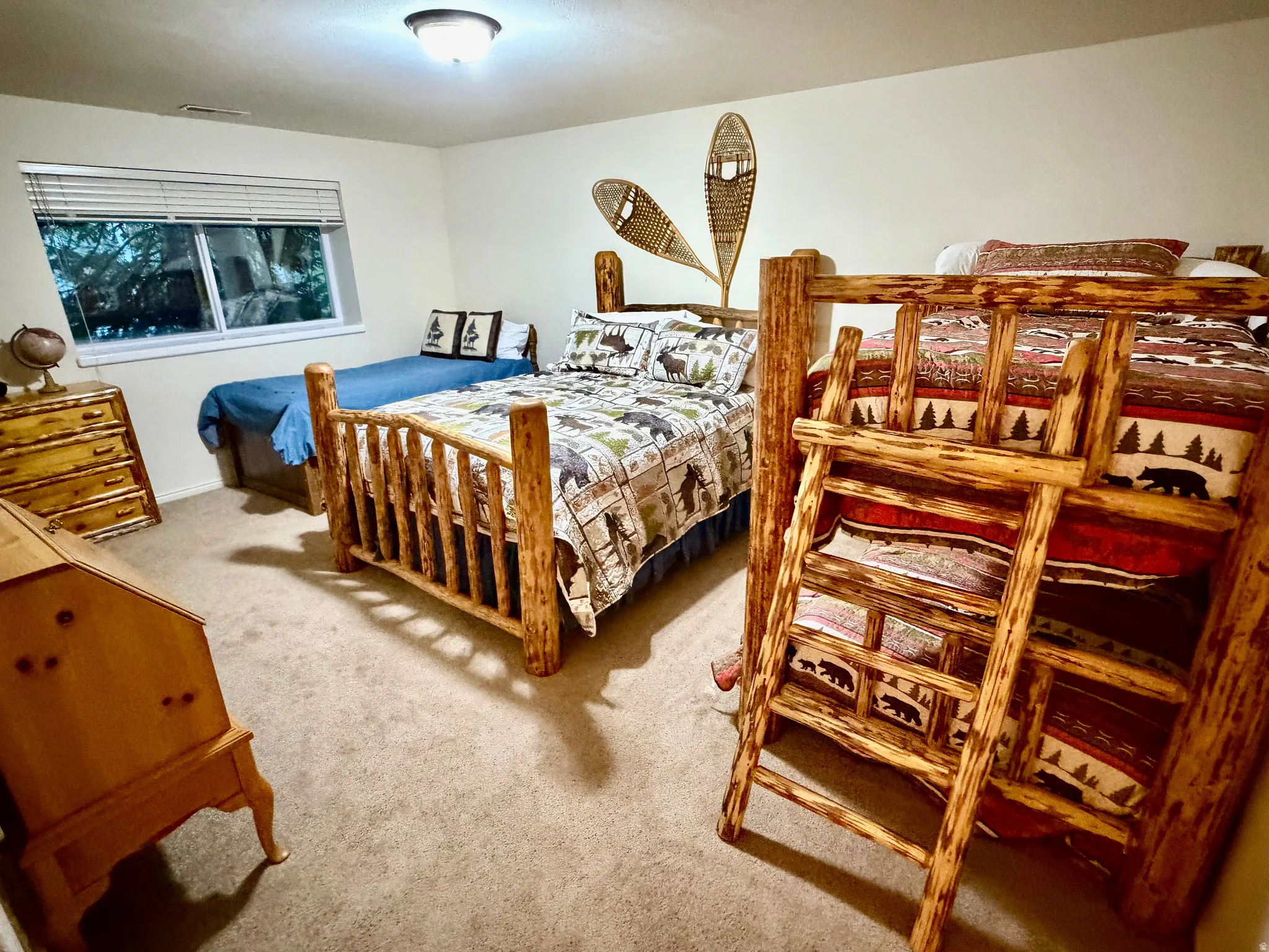 Spacious room featuring neutral carpeting, a large window with horizontal blinds, and a flush-mount ceiling light fixture