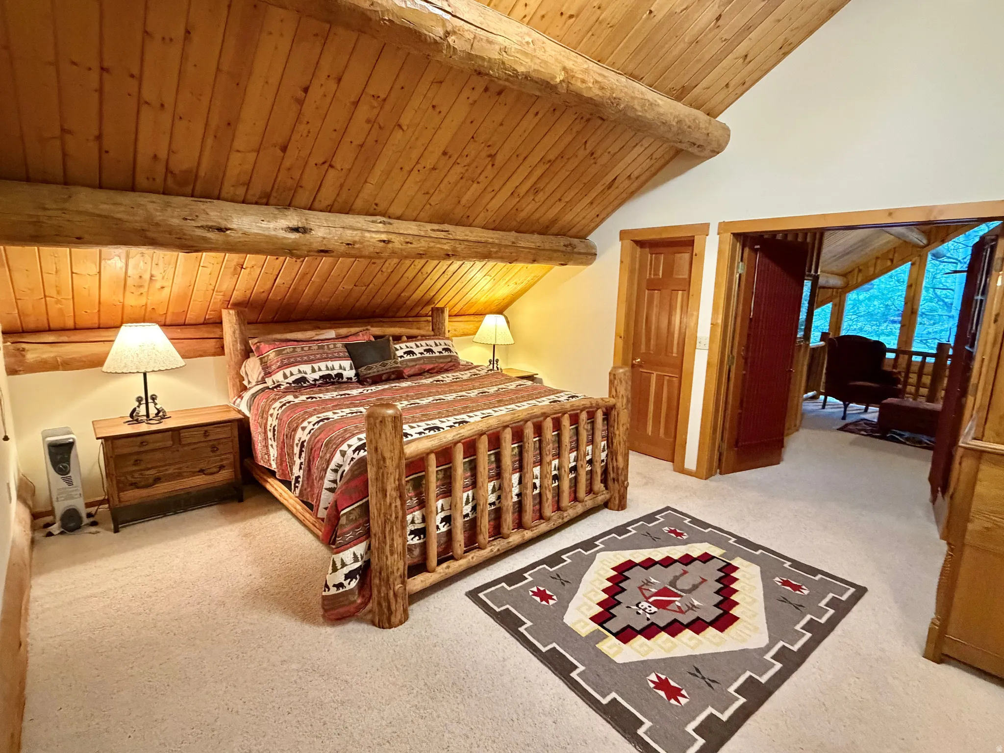Cathedral wood-paneled ceiling featuring exposed log beams