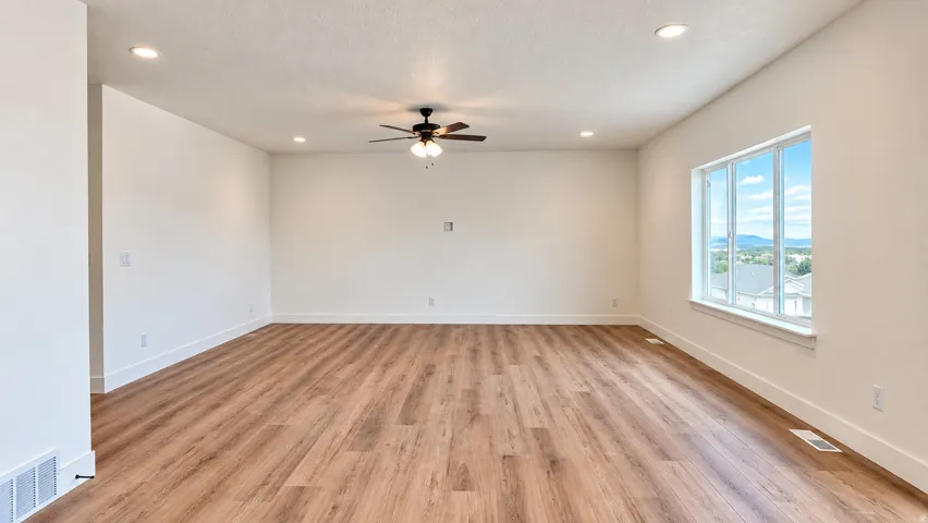 Spacious interior featuring wood-finish flooring, recessed lighting, and a contemporary ceiling fan
