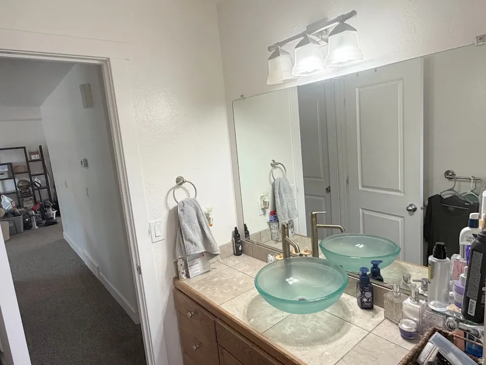 Double vessel sinks with brushed nickel fixtures set on a tiled countertop