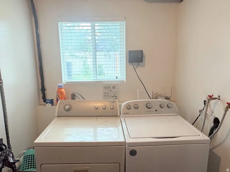 Dedicated laundry area featuring a window, light-colored walls, and utility hookups