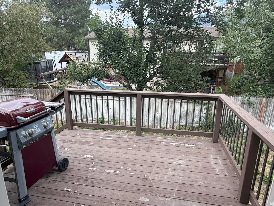 Wood deck featuring a dark brown railing with vertical black balusters