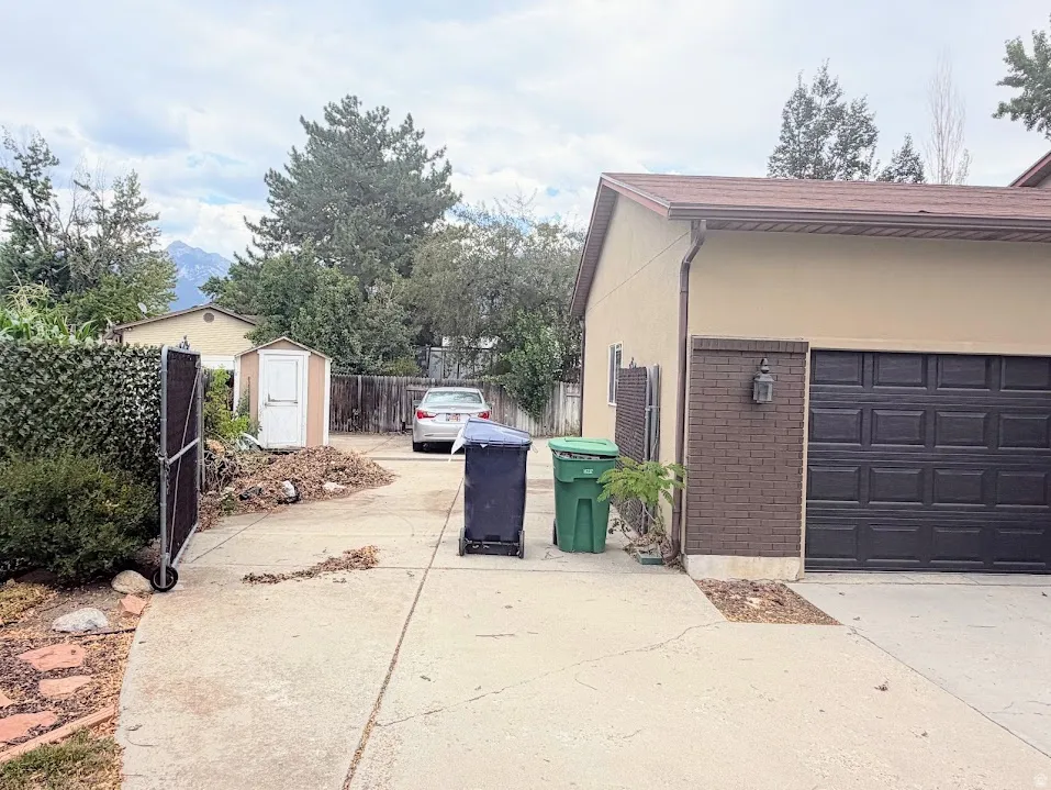 Two-car garage with a paneled dark brown door and brick accent siding