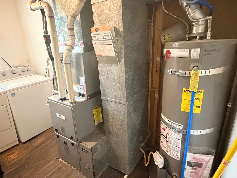 Dedicated utility area featuring a water heater, furnace, and washer/dryer hookups