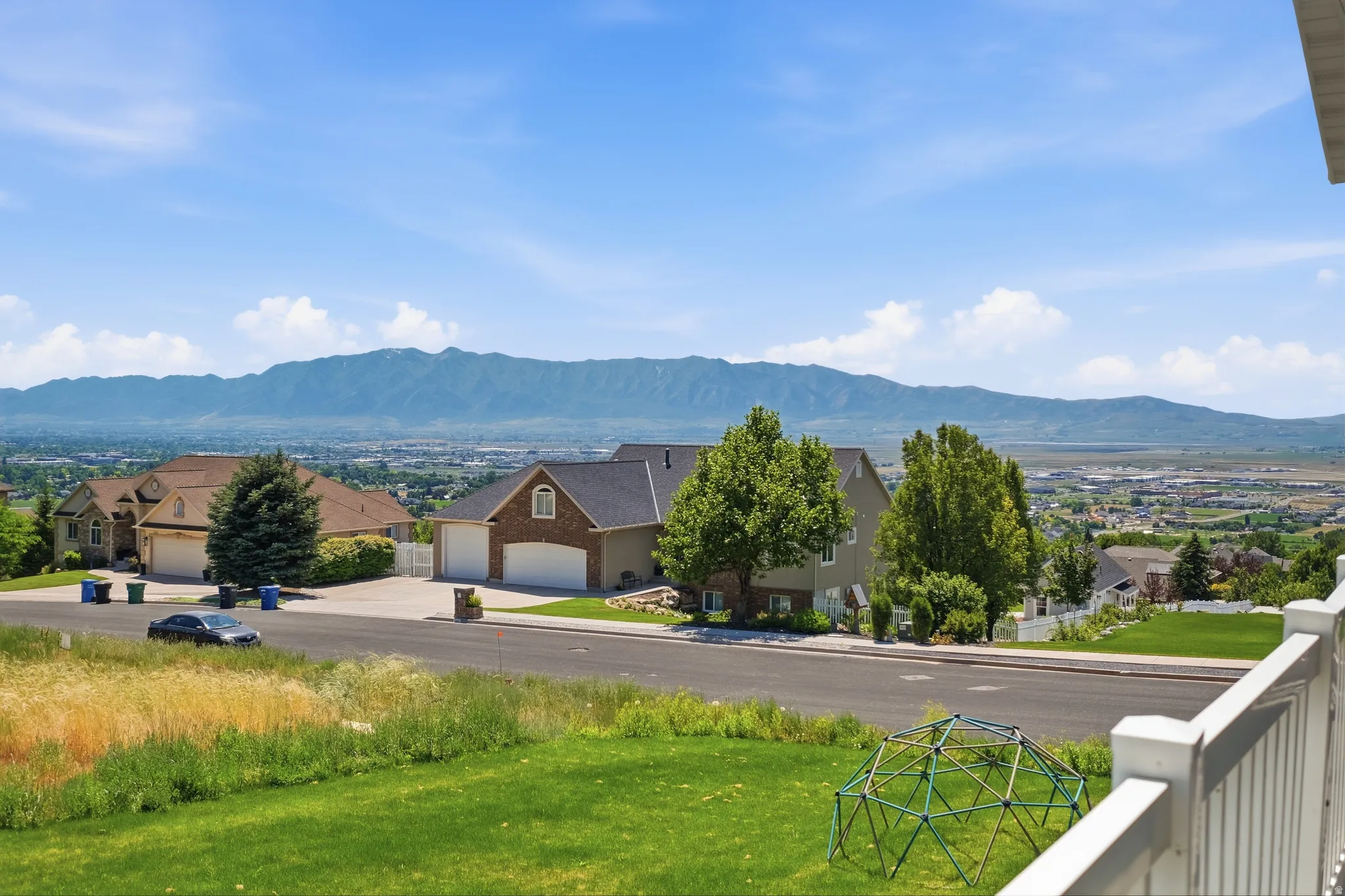 Distant mountain range framing the horizon, with residential properties and a townscape in the mid-ground