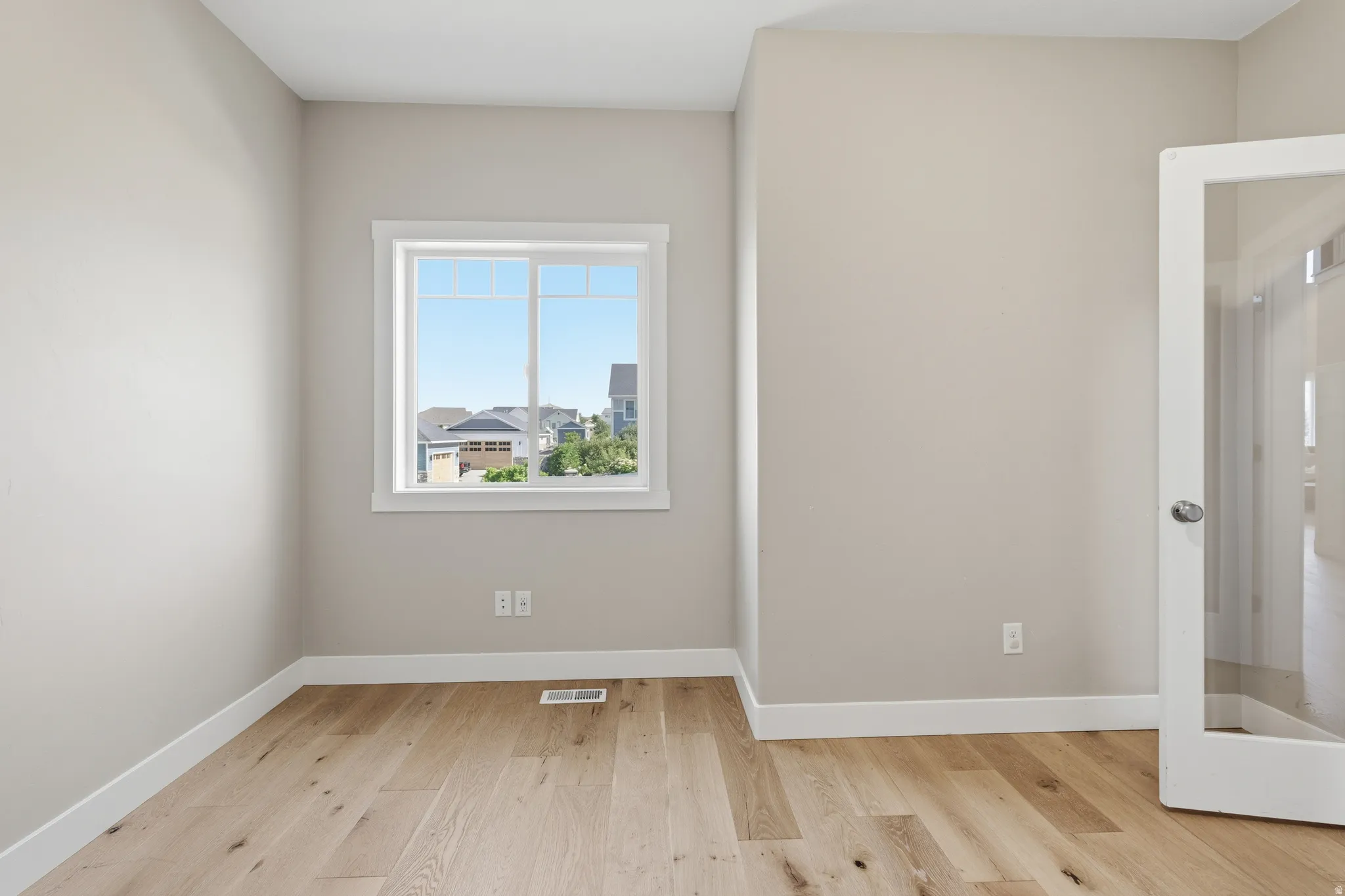 Room with light wood-finish flooring and neutral wall tones