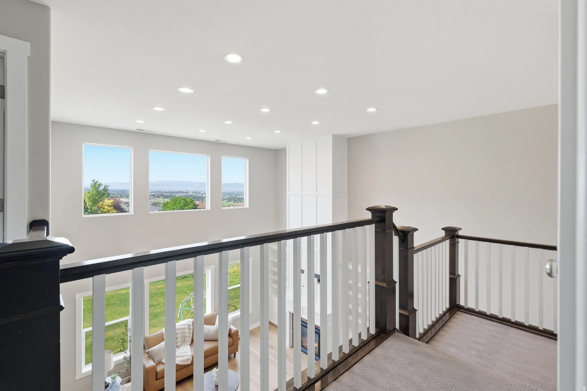 Upper level overlooking a great room with multiple windows