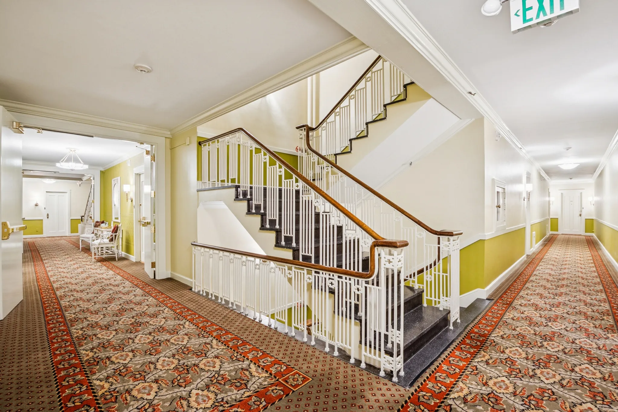 Grand staircase featuring white balusters and wood handrails