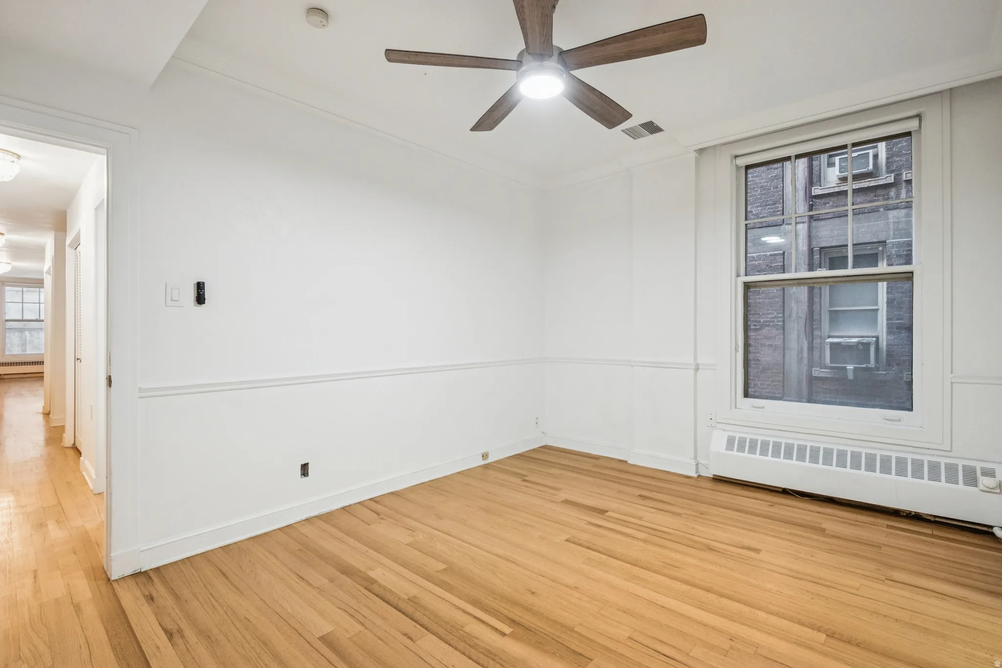 Bedroom 2 featuring hardwood flooring, white walls