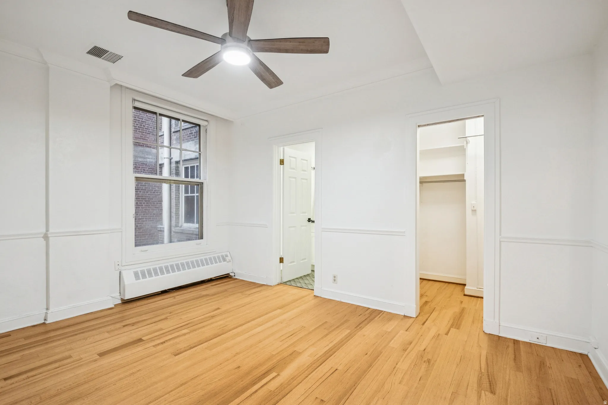 Bedroom 2 featuring hardwood flooring, white walls