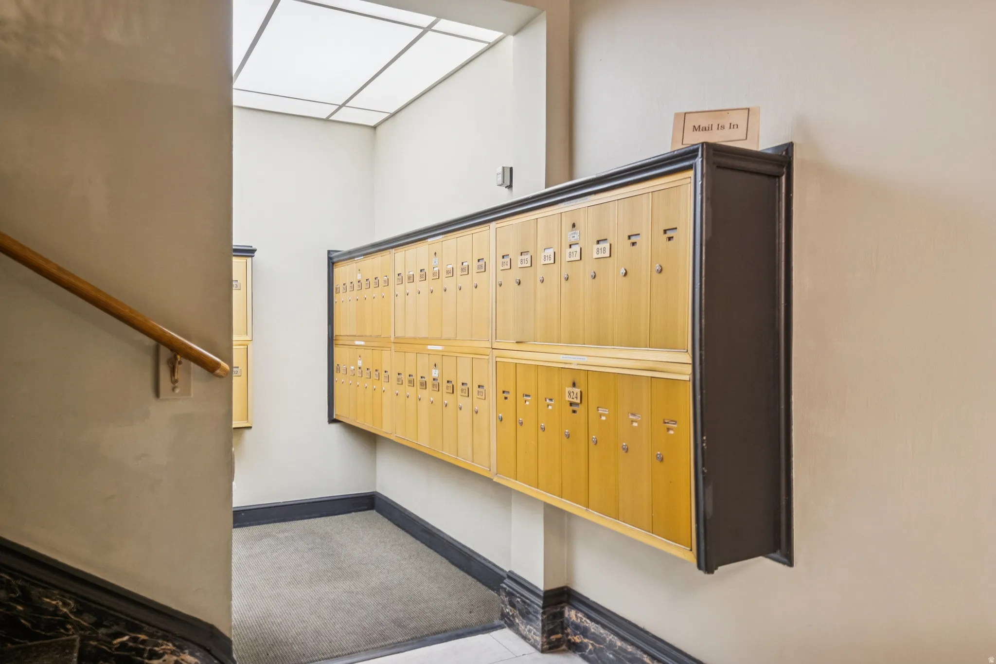 Wall-mounted mailboxes with wood paneling and dark trim