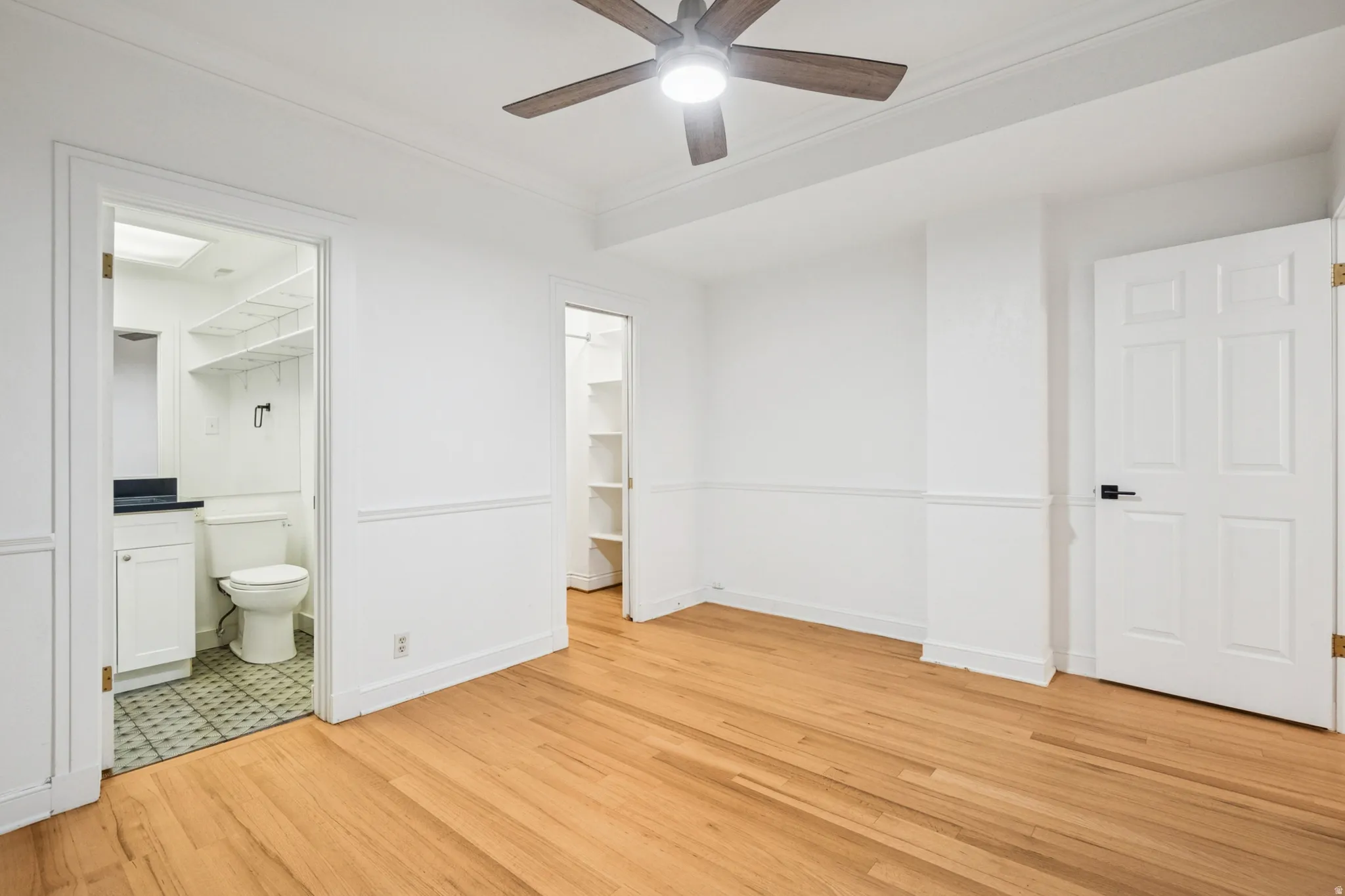 Bedroom 2 featuring hardwood flooring, white walls, and bathroom