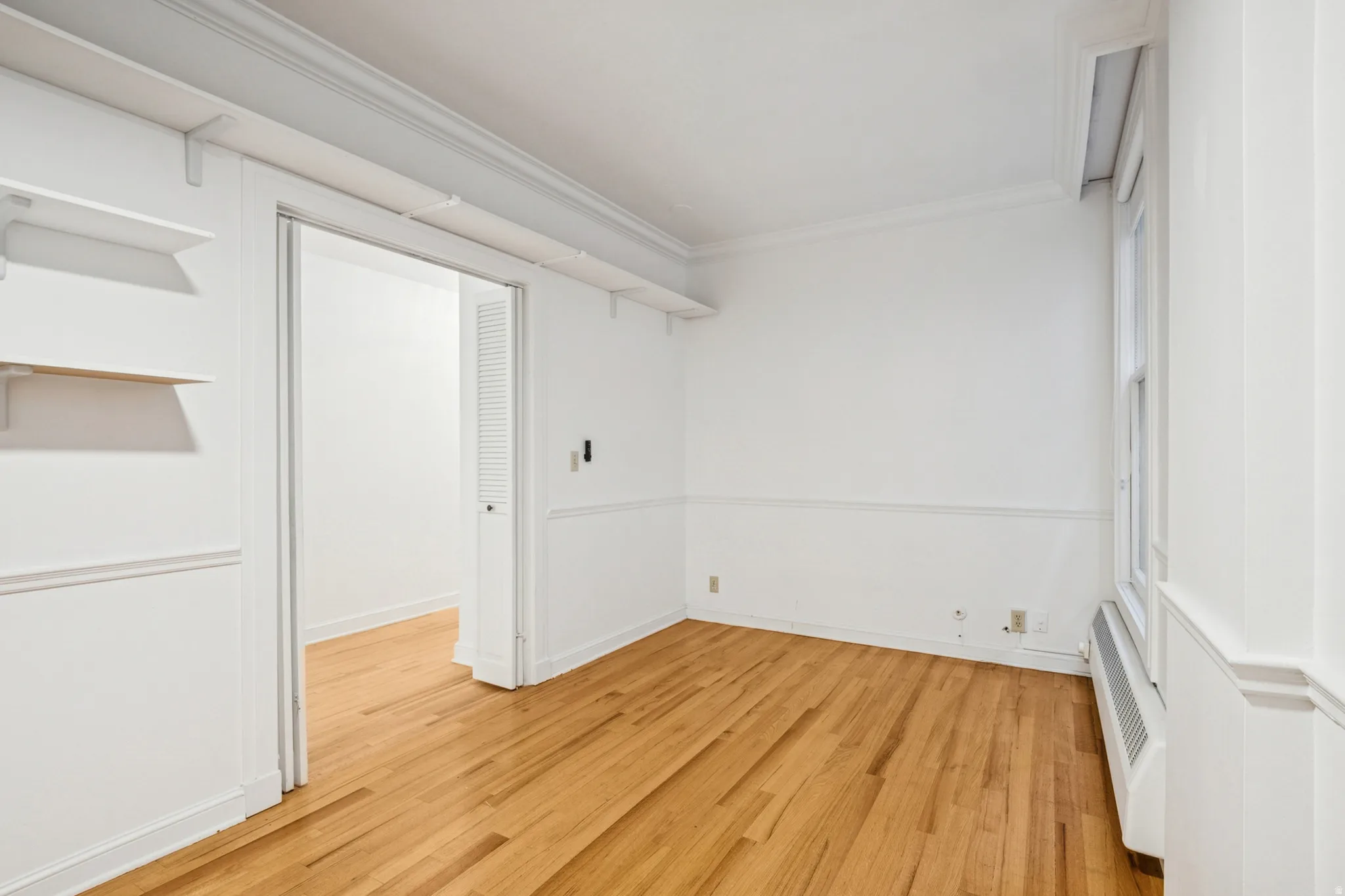 Bedroom 1 featuring hardwood flooring, white walls