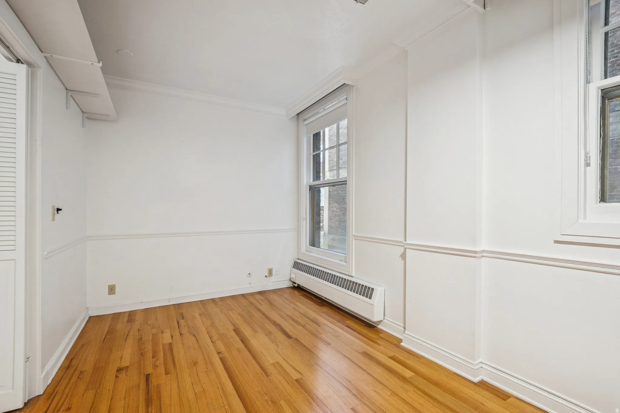 Bedroom 1 featuring hardwood flooring, white walls