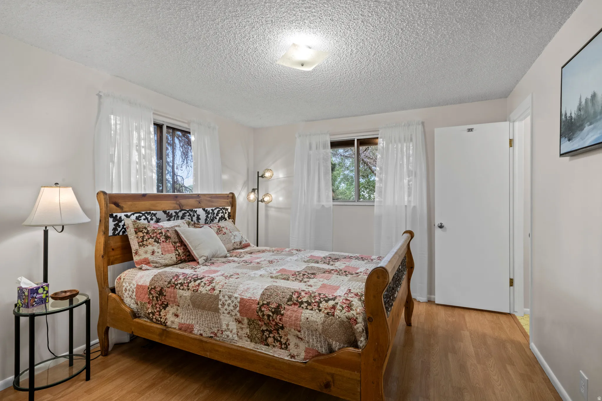 Wood-finish flooring with white walls and a textured ceiling