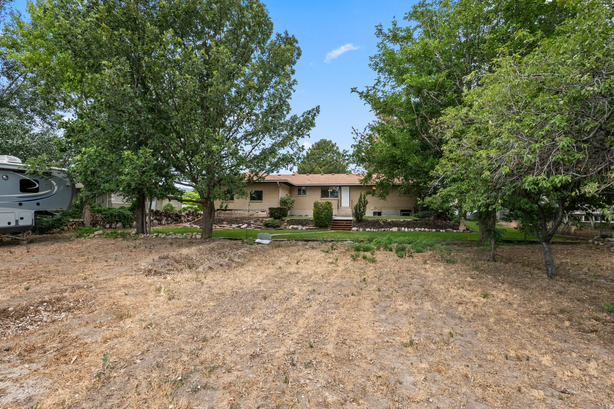 Ranch-style residence featuring a light-colored exterior and a brown shingle roof