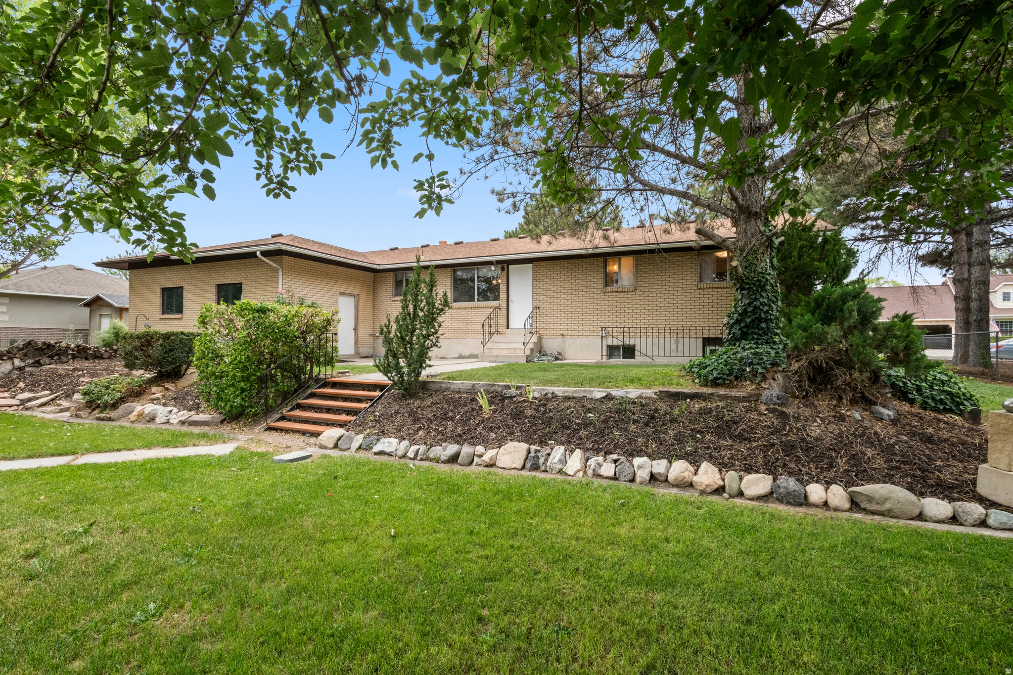 Brick exterior residence featuring a back yard with mature trees