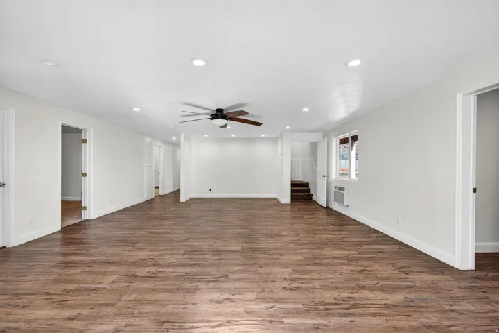 Spacious room featuring wood-finish flooring, recessed lighting, and a ceiling fan