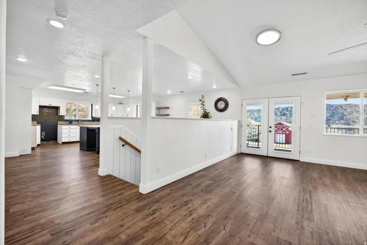 Spacious open-concept interior featuring wood-finish flooring, white walls, and recessed lighting