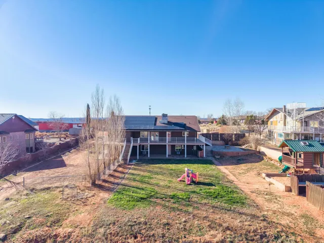 Rear exterior featuring a two-story design with a full-width upper deck and a ground-level patio