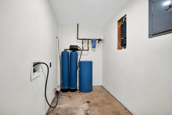 Utility room featuring a water filtration system, water softener, and electrical panel