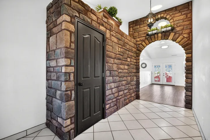 Stone-clad archway entryway featuring a decorative hanging lantern and an upper arch accent