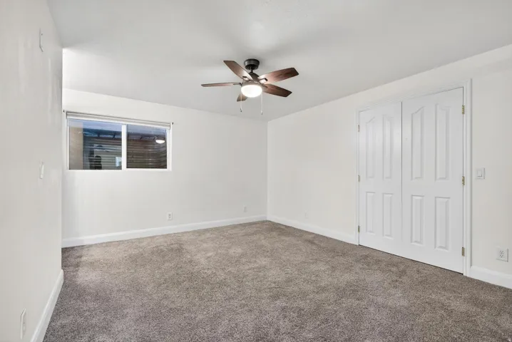 Spacious room featuring neutral carpeting and white walls