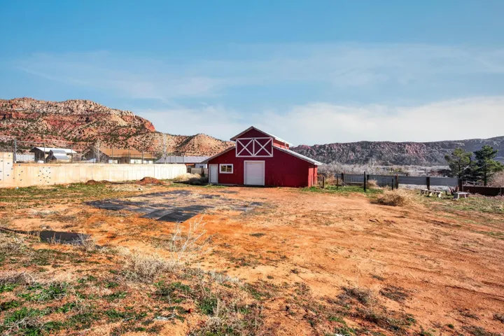 Red barn structure with white trim and a prominent gable