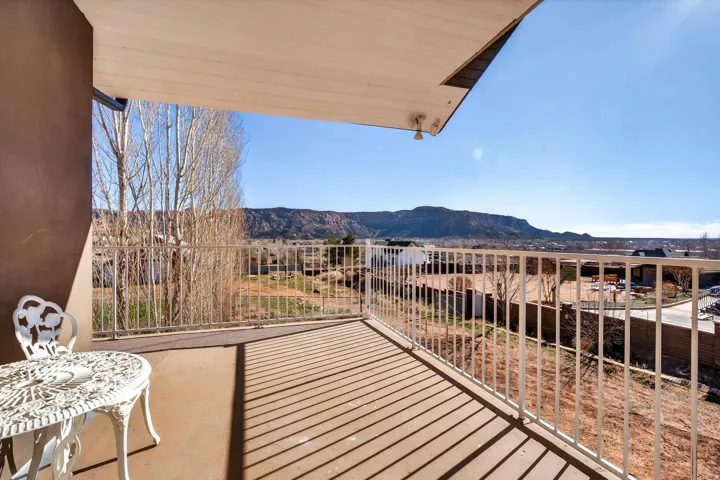 Expansive balcony featuring a white metal railing and a distant mountain backdrop