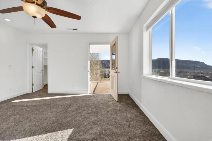 Room featuring carpet flooring, white walls, and a ceiling fan with integrated lighting
