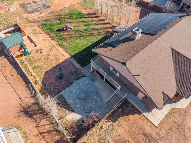 Expansive rear exterior featuring a brown shingle roof, solar panel array, and a multi-level deck with white railings