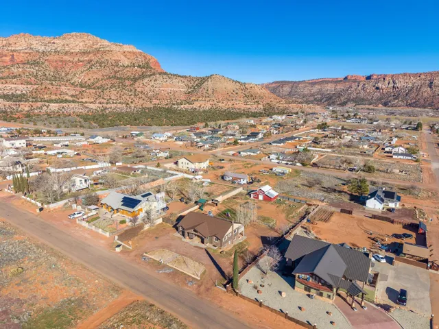Residential community featuring a variety of housing styles, red rock mountain backdrop, and clear blue skies