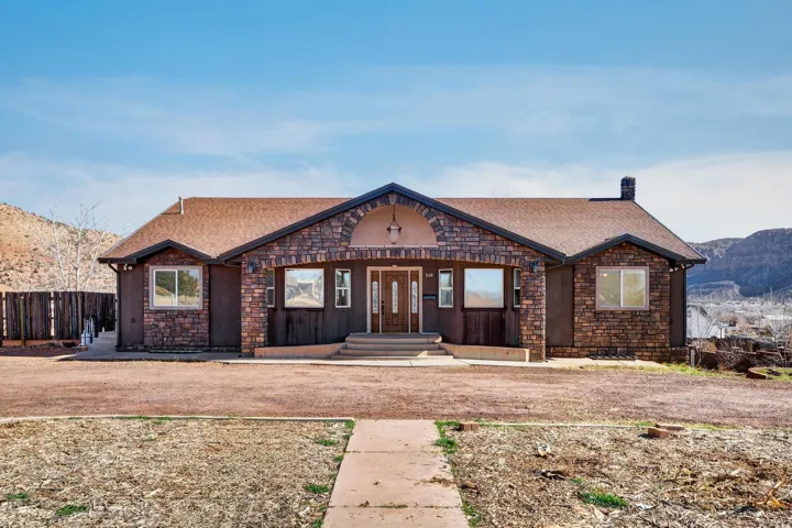 Single-story residence featuring stone veneer siding with contrasting smooth stucco accents