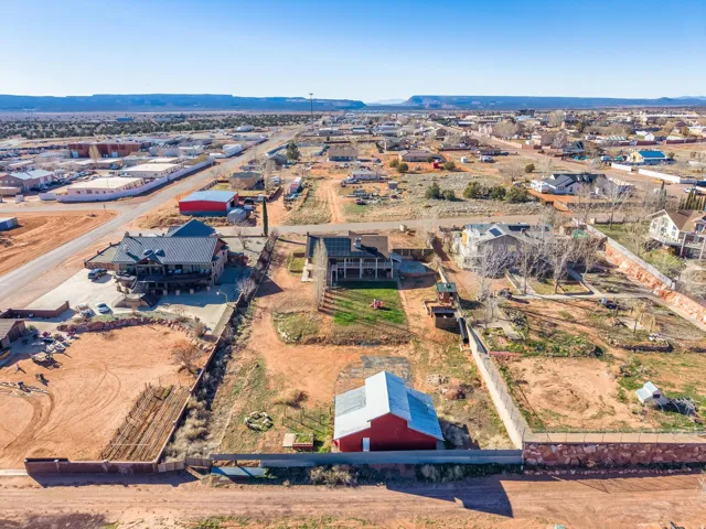 Expansive property featuring a red barn, perimeter fencing, and a terraced backyard area