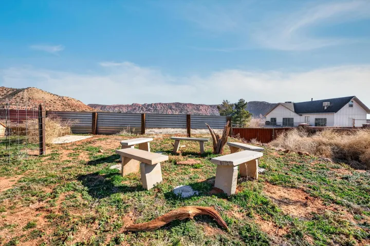 Outdoor gathering space featuring five stone benches arranged around a central area