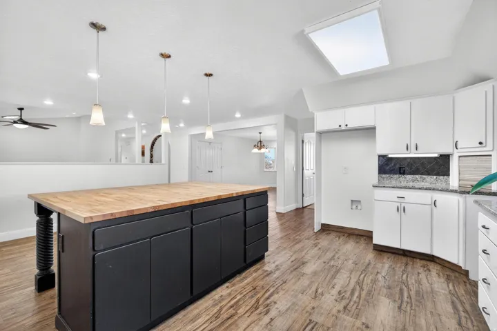 Kitchen featuring a large central island with a wood countertop and dark cabinetry