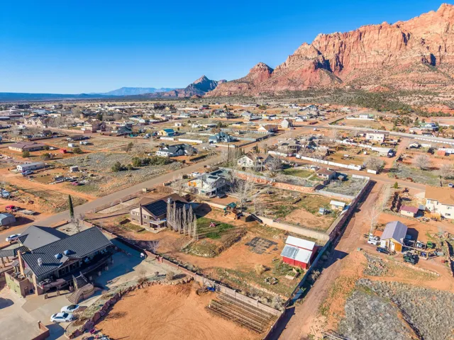 Expansive aerial perspective showcasing a community situated against a backdrop of natural rock formations