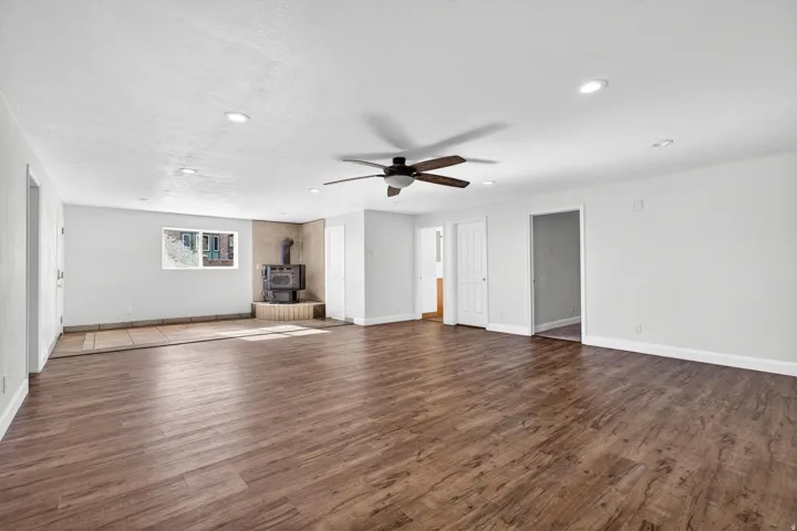 Spacious living area featuring wood-finish flooring, recessed lighting, and a ceiling fan