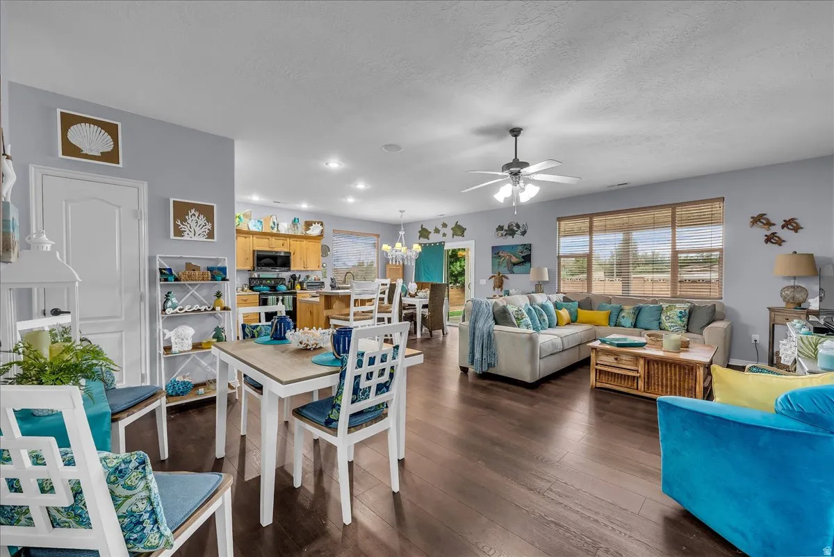 Open-concept living area with dark wood-finish flooring, recessed lighting, and a ceiling fan