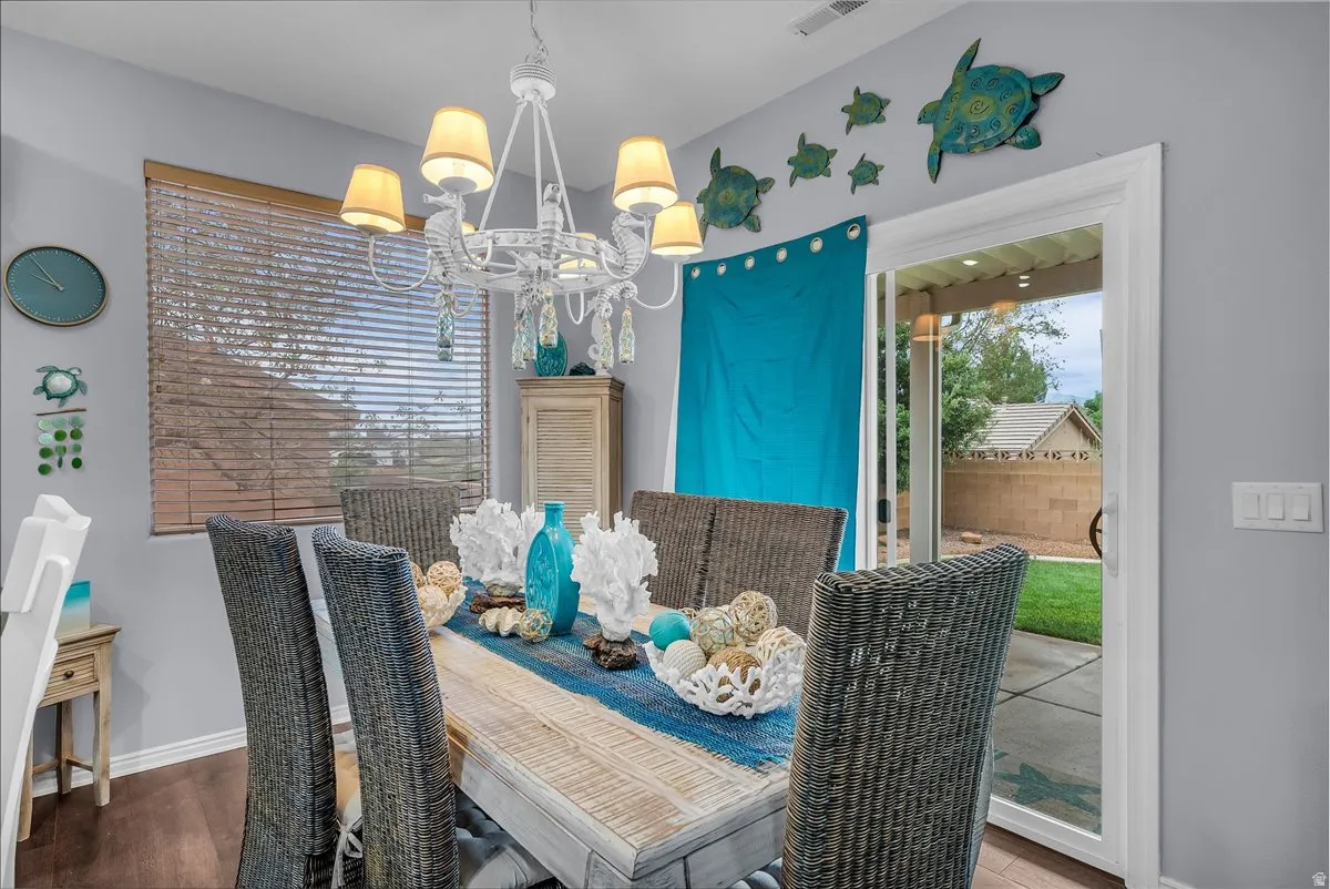 Dining area featuring wood-finish flooring, a contemporary chandelier, and a sliding glass door leading to an outdoor patio