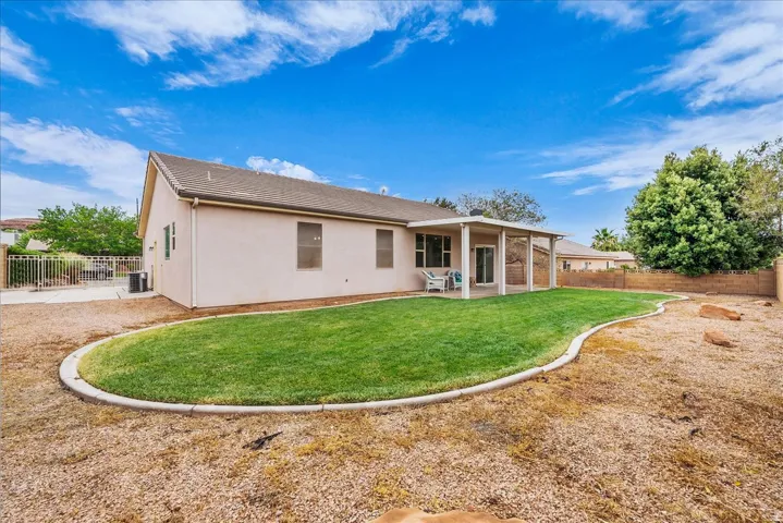Expansive backyard featuring a curved lawn area with concrete curbing and a gravel landscape section