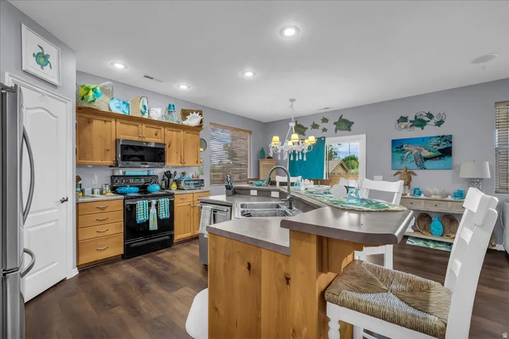 Spacious kitchen featuring wood cabinetry, dark wood-finish flooring, a stainless steel refrigerator, and a built-in microwave
