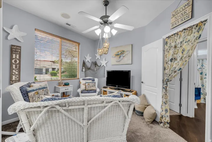 Living area featuring light gray wall paint and a textured carpeted floor