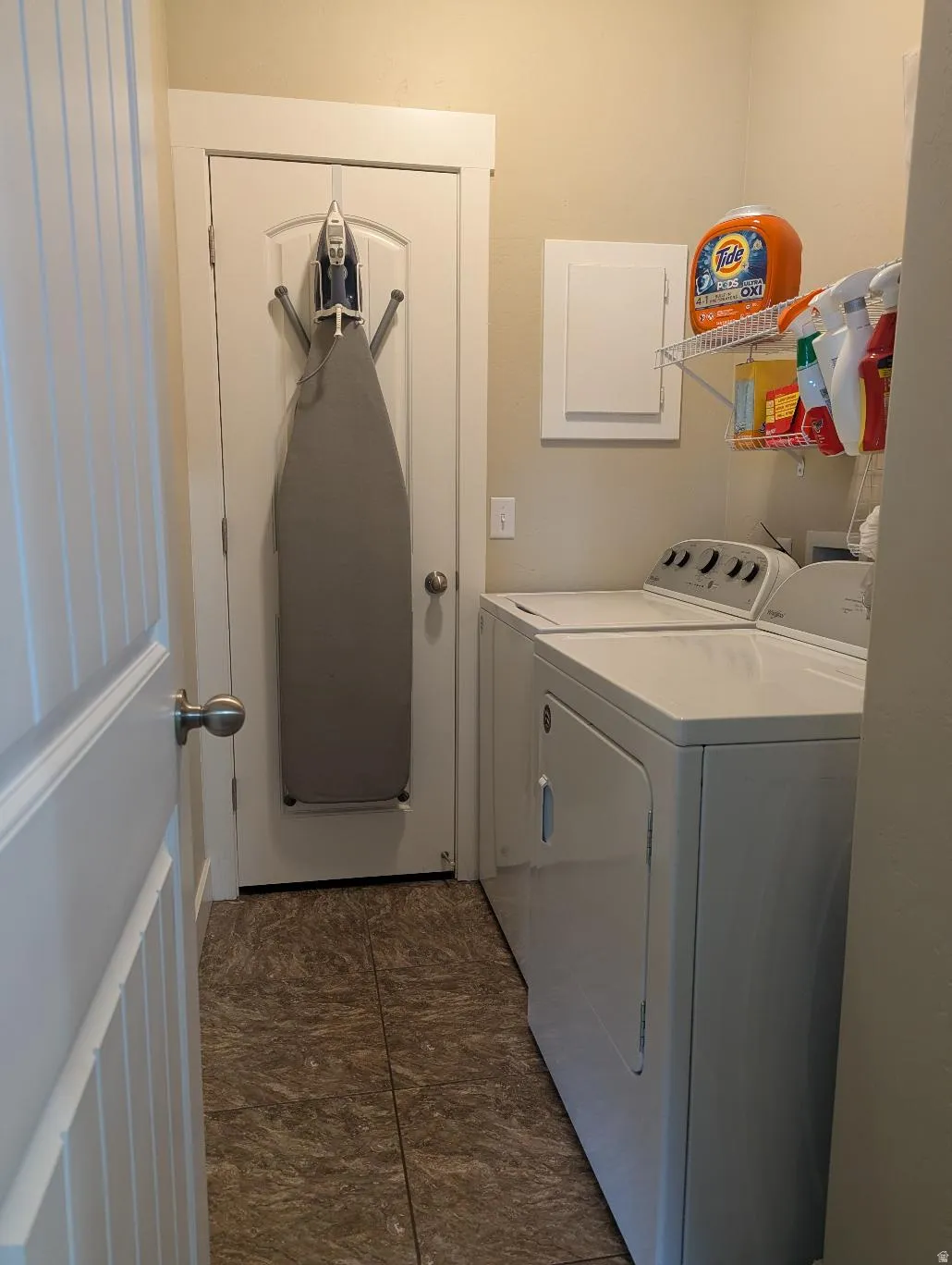 Dedicated laundry area featuring a washer and dryer, tile flooring, and a wall-mounted storage shelf