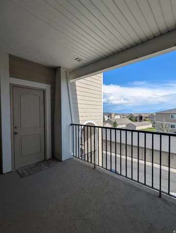 Covered balcony with textured flooring and black metal railings