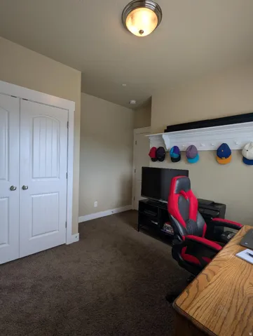 Room featuring neutral wall tones and dark carpeting