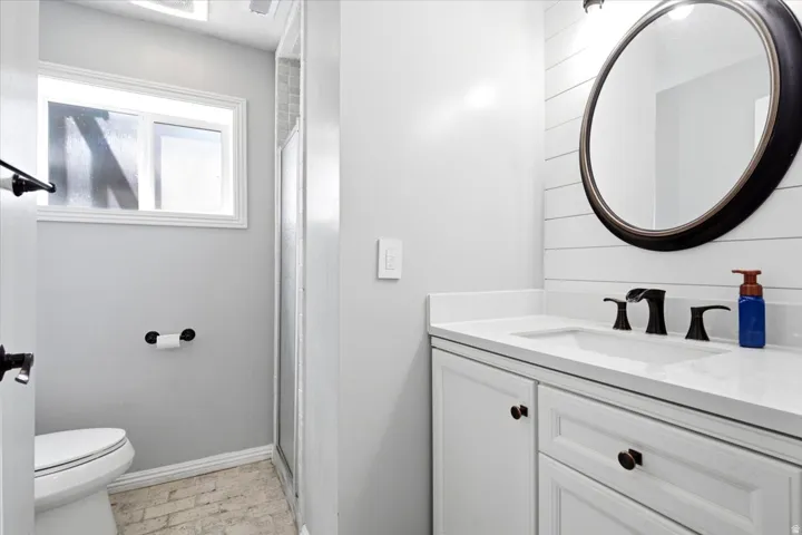 Bathroom featuring a white vanity with an integrated sink, quartz-finish countertop, and dark-bronze fixtures