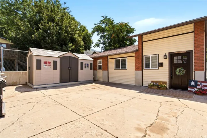 Exterior featuring beige siding, brick accents, and a dark entry door with frosted glass panes