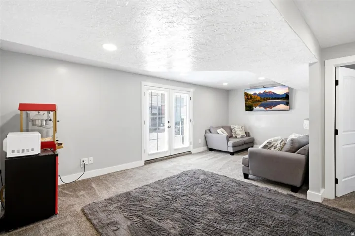 Carpeted living area featuring recessed lighting and a wall-mounted television